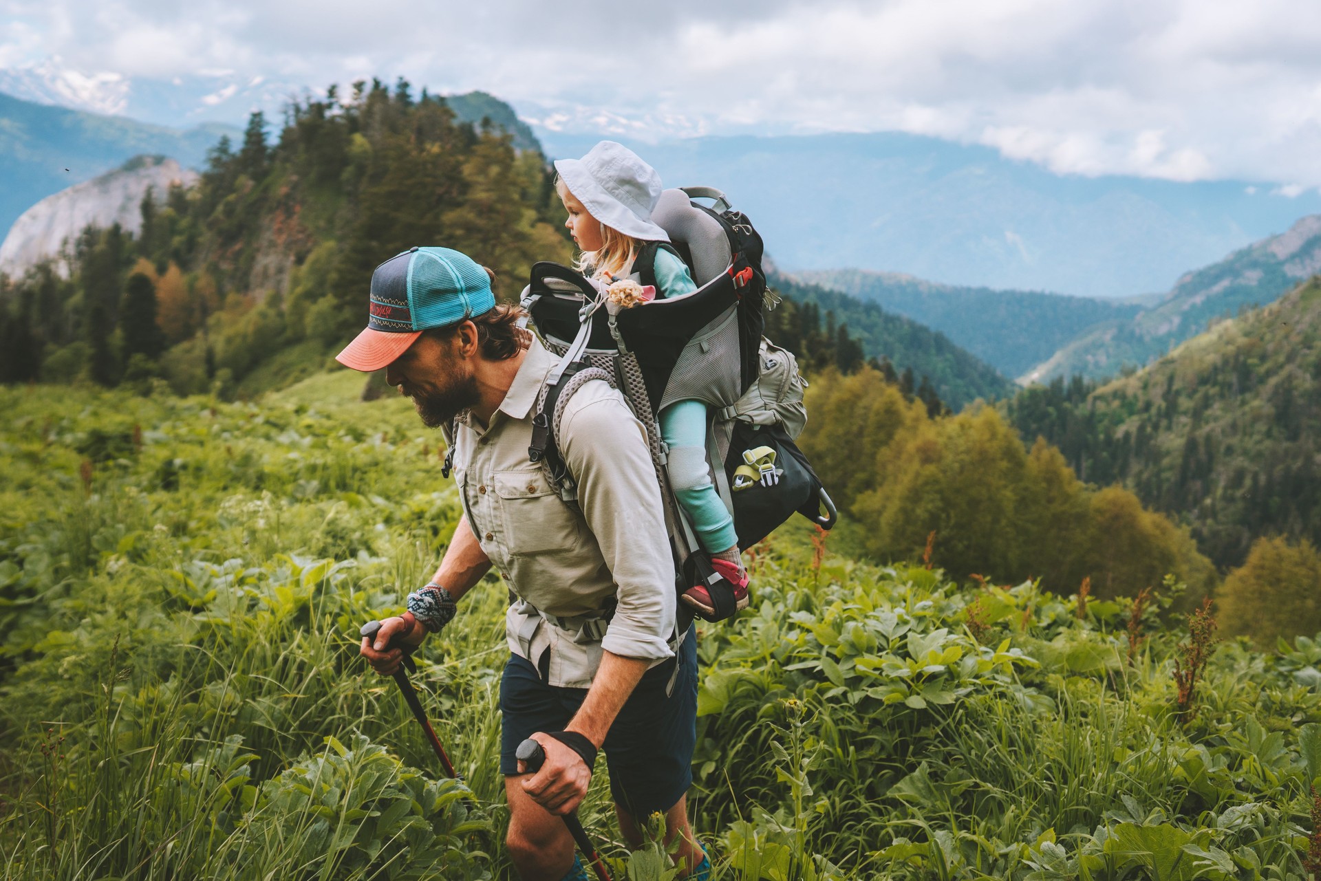 Family hiking father with child in backpack traveling together in mountains healthy lifestyle adventure trip summer vacations outdoor